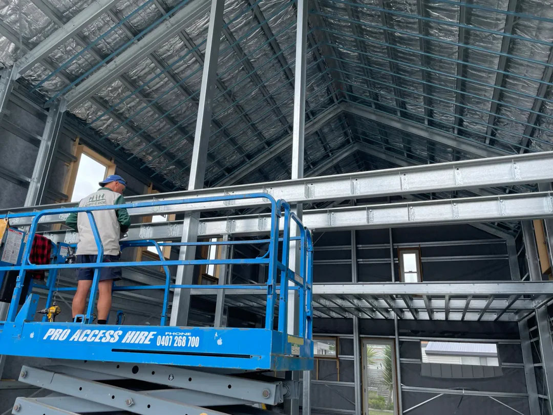 Mezzanine floor bearers being installed from a scissor lift inside the frame