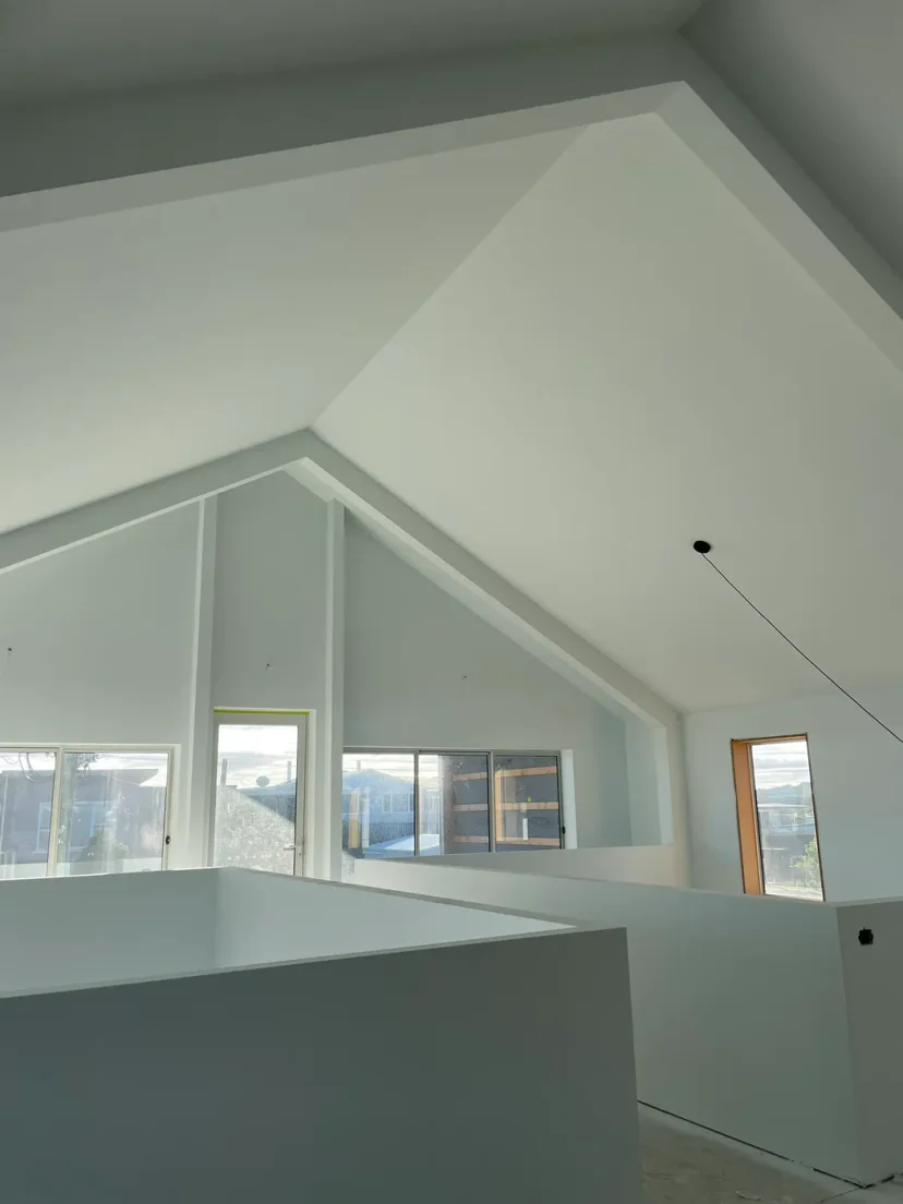 The plastered double-height void of Shed Home #03 with highlight windows
