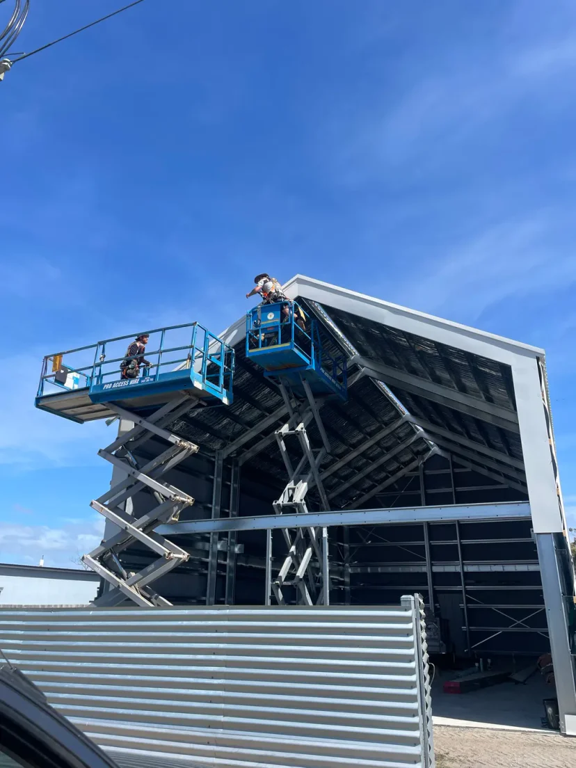 Wall cladding being fixed to the gable end from a scissor lift