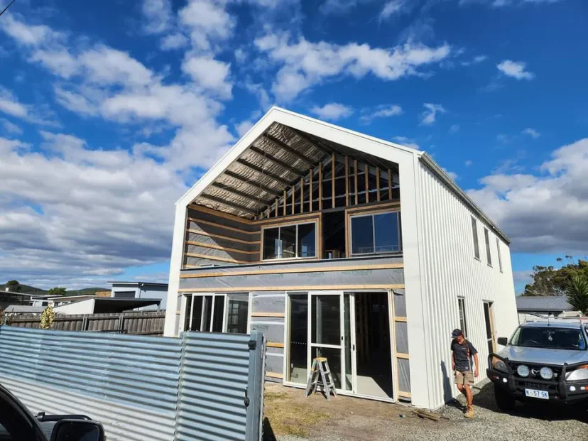 Shed Home #03 at lock-up seen from the street — clad, roofed, windows in