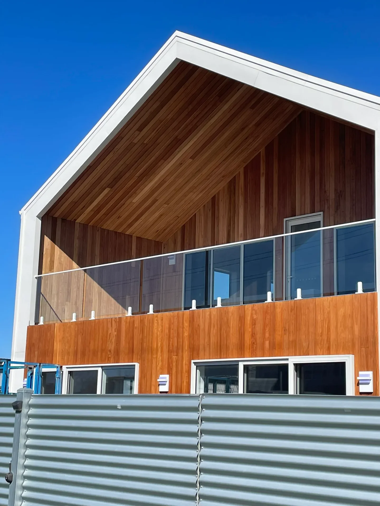 Shed Home #03 at Weymouth, Tasmania — finished, with a timber-clad gable and glass balustrade