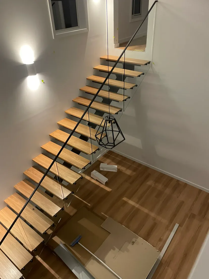 The timber and steel stair rising to the mezzanine inside the finished home