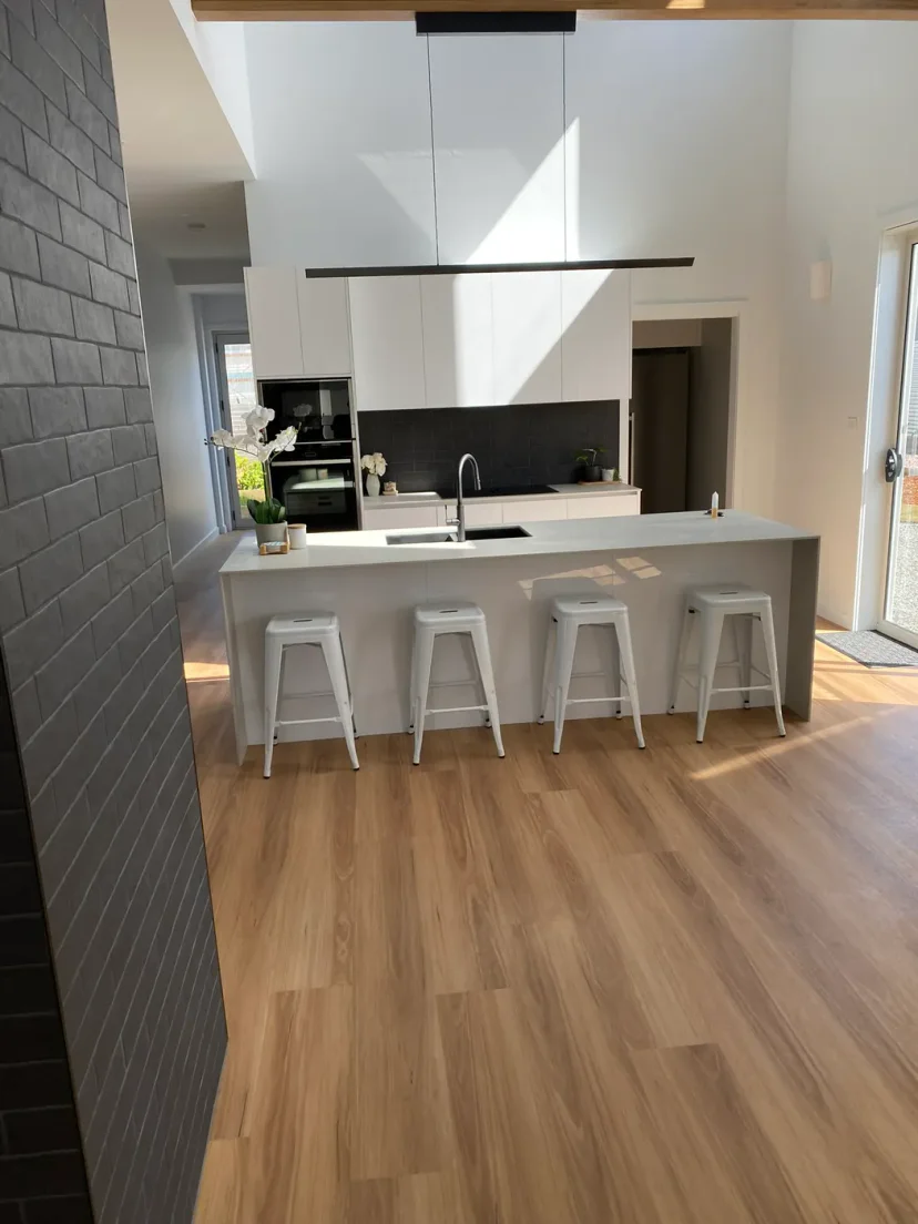 The finished kitchen island with stools, looking out to the deck